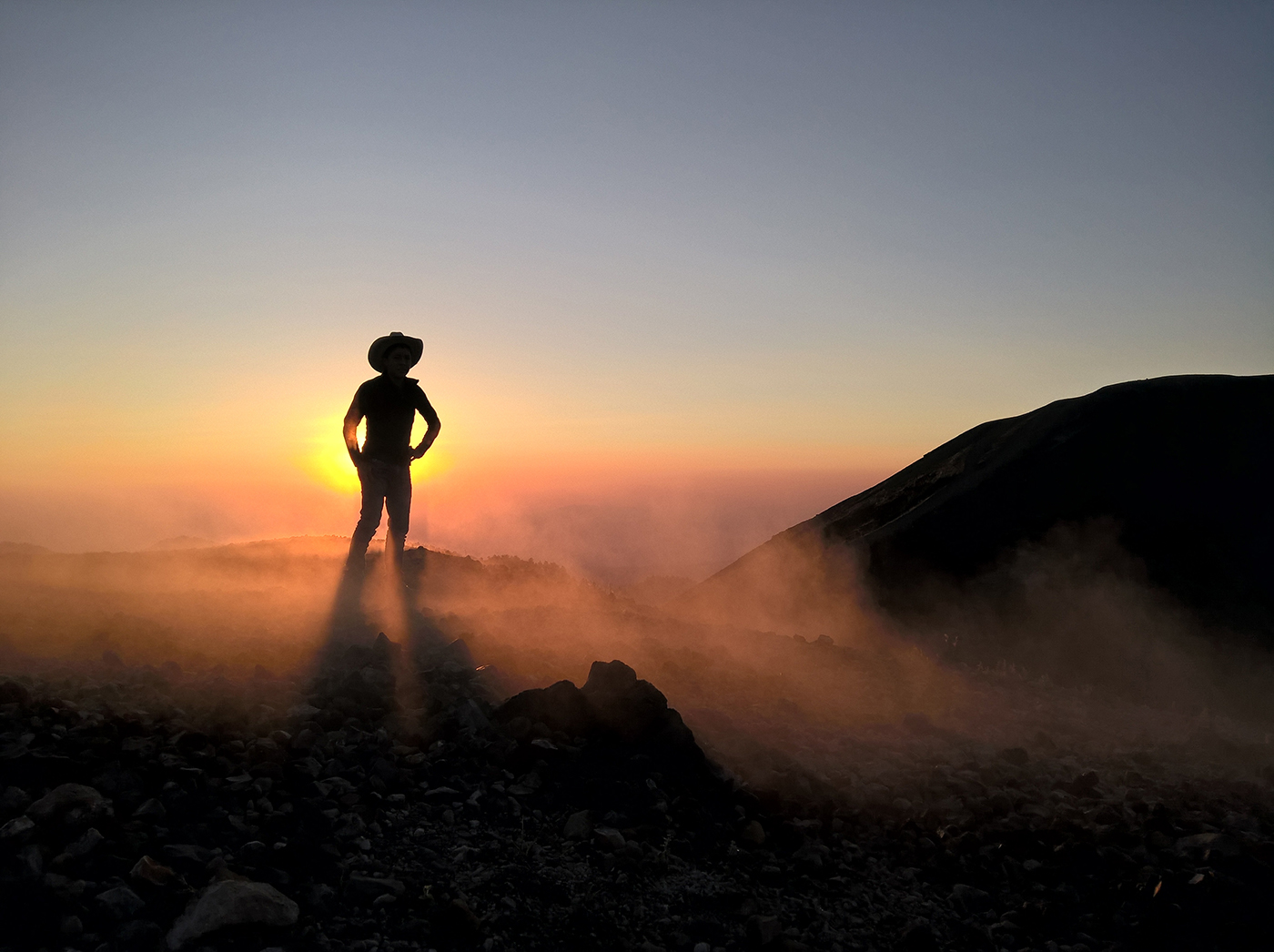 Pedro Perucho stands on the steaming rim of Paricutin Volcano. The volcano is technically extinct but still emits clouds of steam.