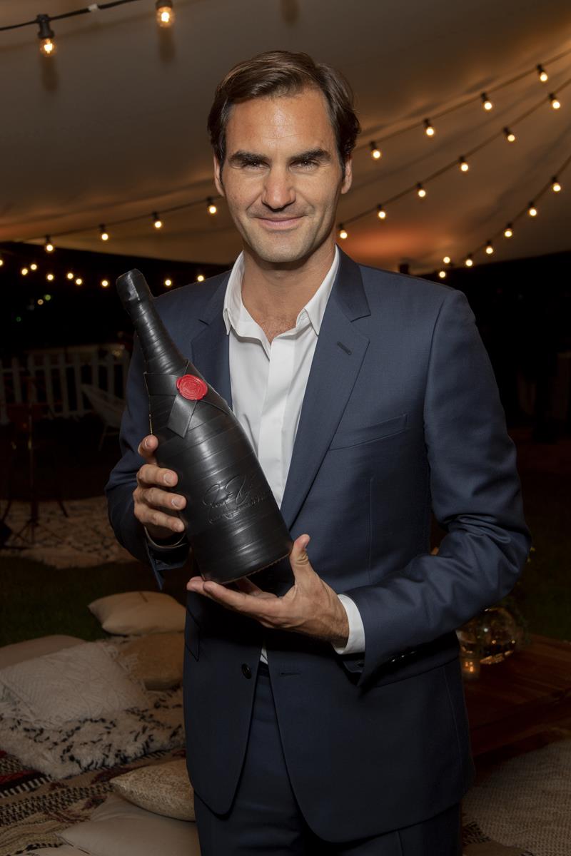 Moët & Chandon Roger Federer Tribute event_Roger Federer posing with 'Greatness Since 1998' magnum bottle